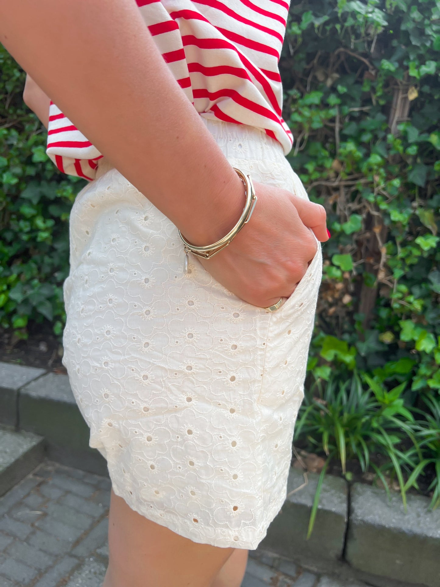 Een crème kleurige short met broderie print, borduursels motief. De short heeft een elastieken band in de taille en valt klein. De short heeft twee steekzakken